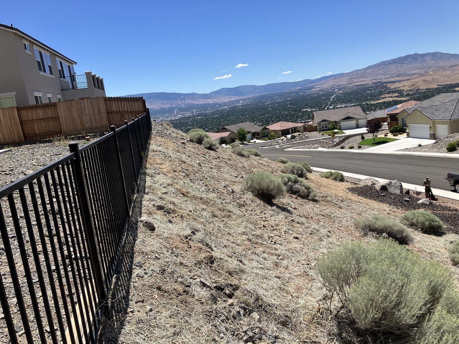 Defensible space strip along a hillside fence line