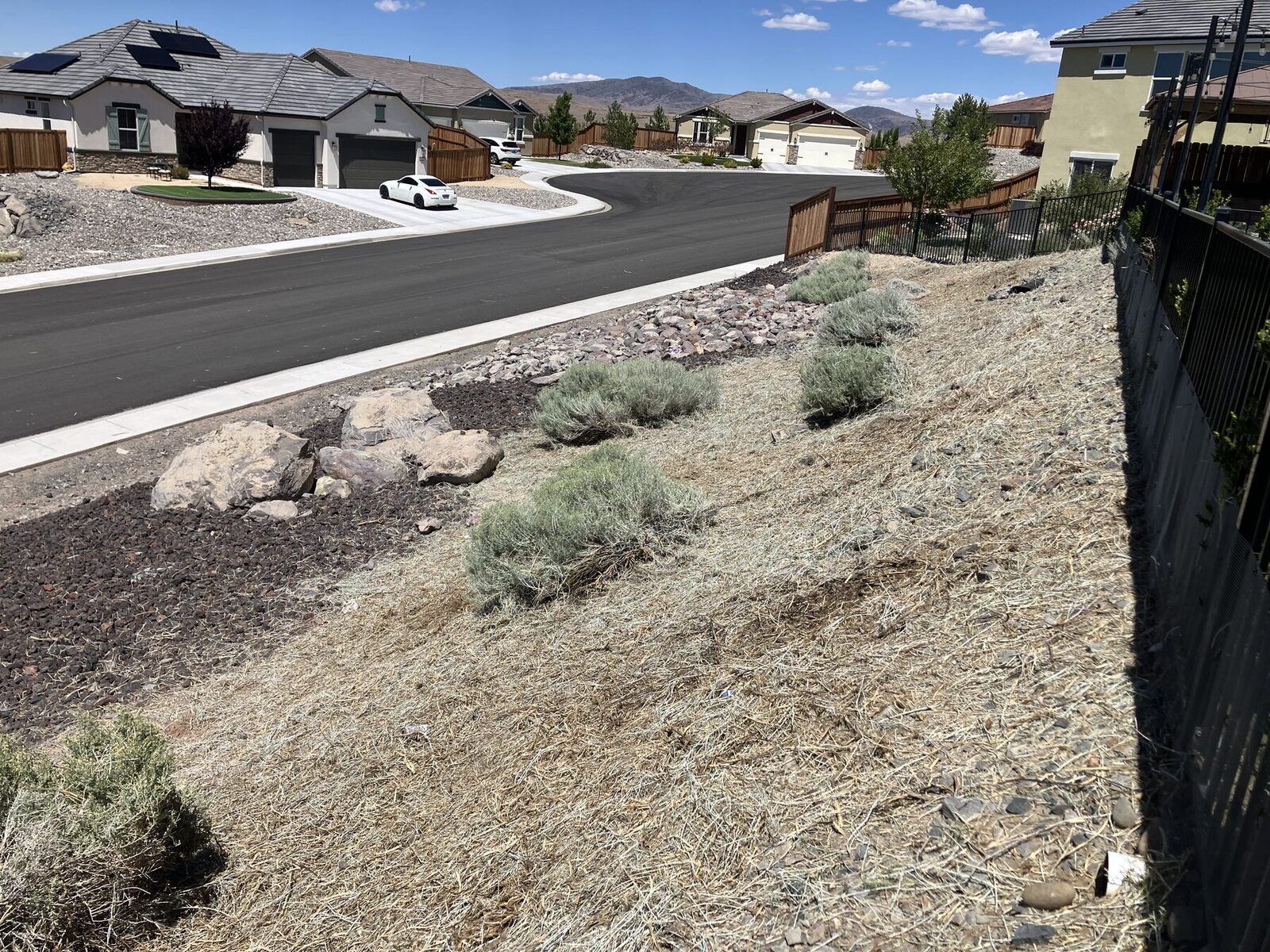 Cleared residential slope with rock mulch and spaced brush